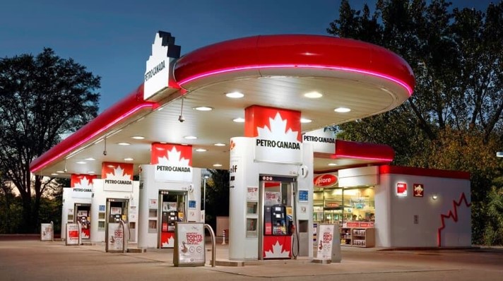 Petro-Canada gas station at dusk, featuring bright red and white branding with a convenience store in the background.