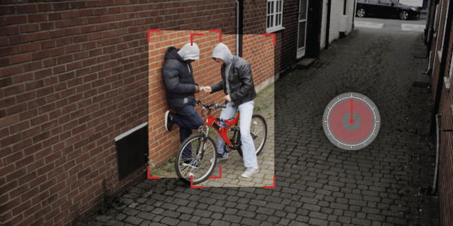 AI-powered surveillance detecting two individuals with a bicycle in an alley, highlighted by red tracking boxes.