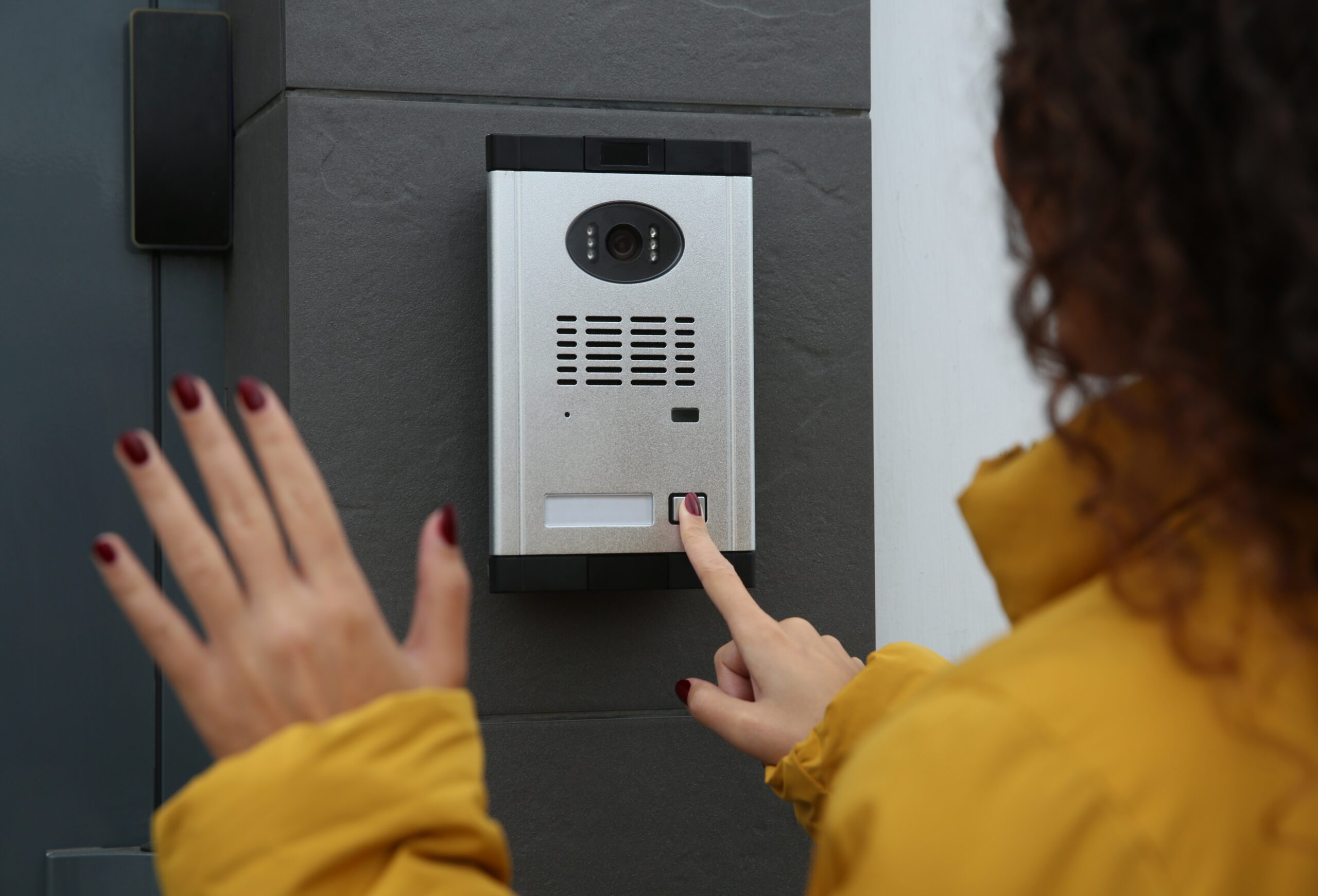 African-american, Woman, Ringing, intercom,While,Waving,To,Camera,Near,Building